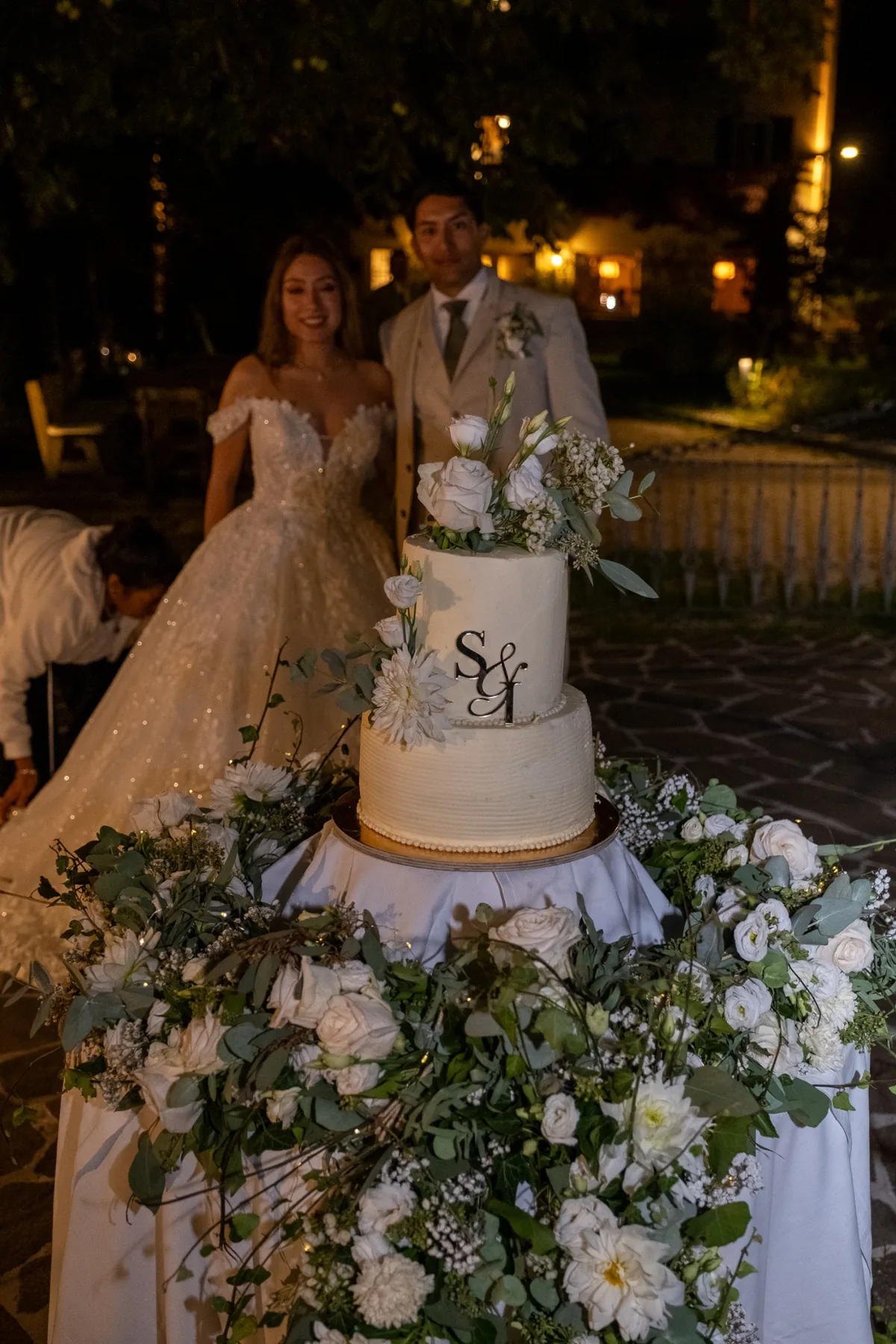 Torta nuziale floreale con gli sposi sullo sfondo
